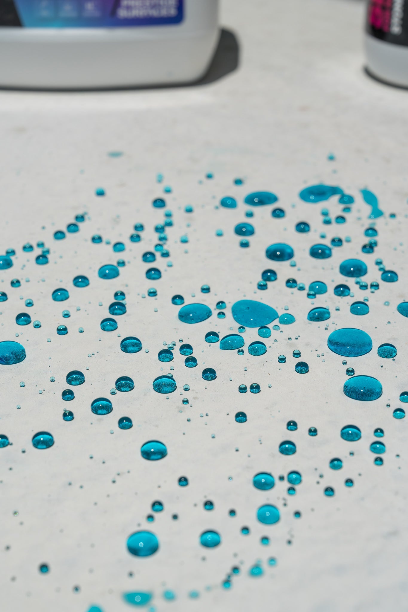 Close-up of blue dye water beading on sealed stone surface, demonstrating Just Seal It penetrating sealer water repellency